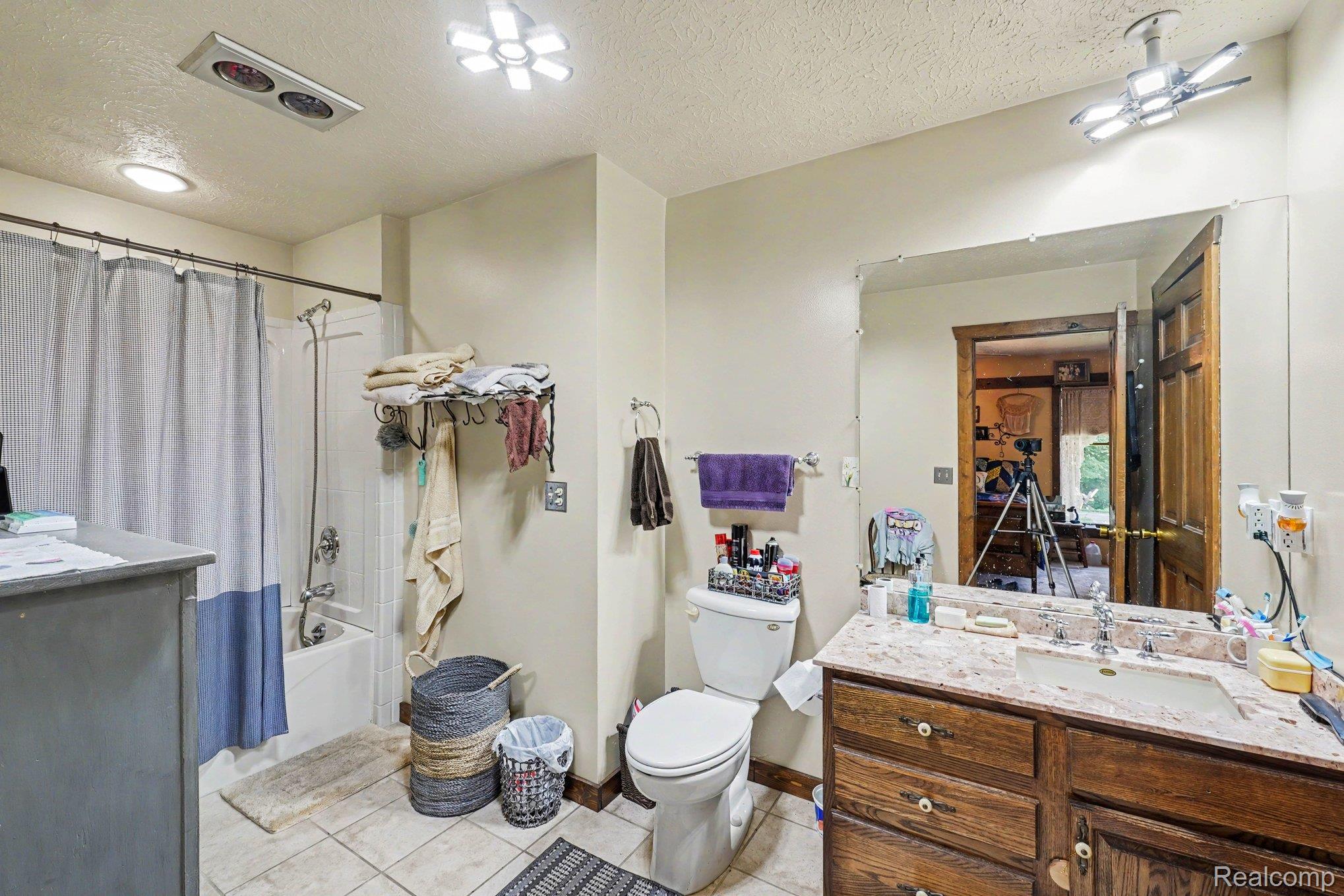 3284 Pratt Road Metamora, MI 48455 - Photo 10 of 17 Bathroom featuring a vanity with wood-finish cabinetry, a single basin sink, and a large wall-mounted mirror