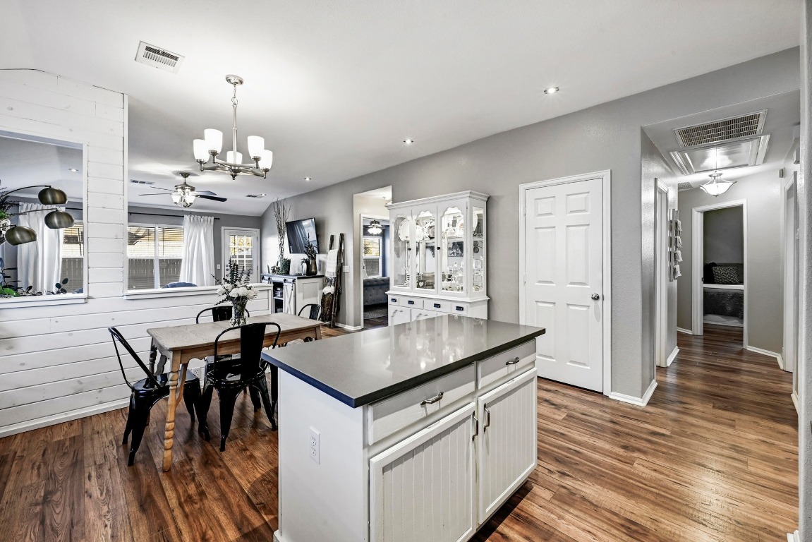 280 Spruce Drive Kyle, TX 78640 - Photo 11 of 30 Kitchen featuring dark countertops, white cabinetry, a kitchen island, decorative light fixtures, and dark wood finished floors