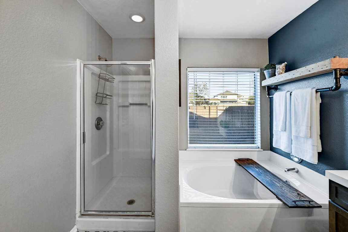 280 Spruce Drive Kyle, TX 78640 - Photo 18 of 30 Full bath featuring a textured wall, a garden tub, a shower stall, and vanity
