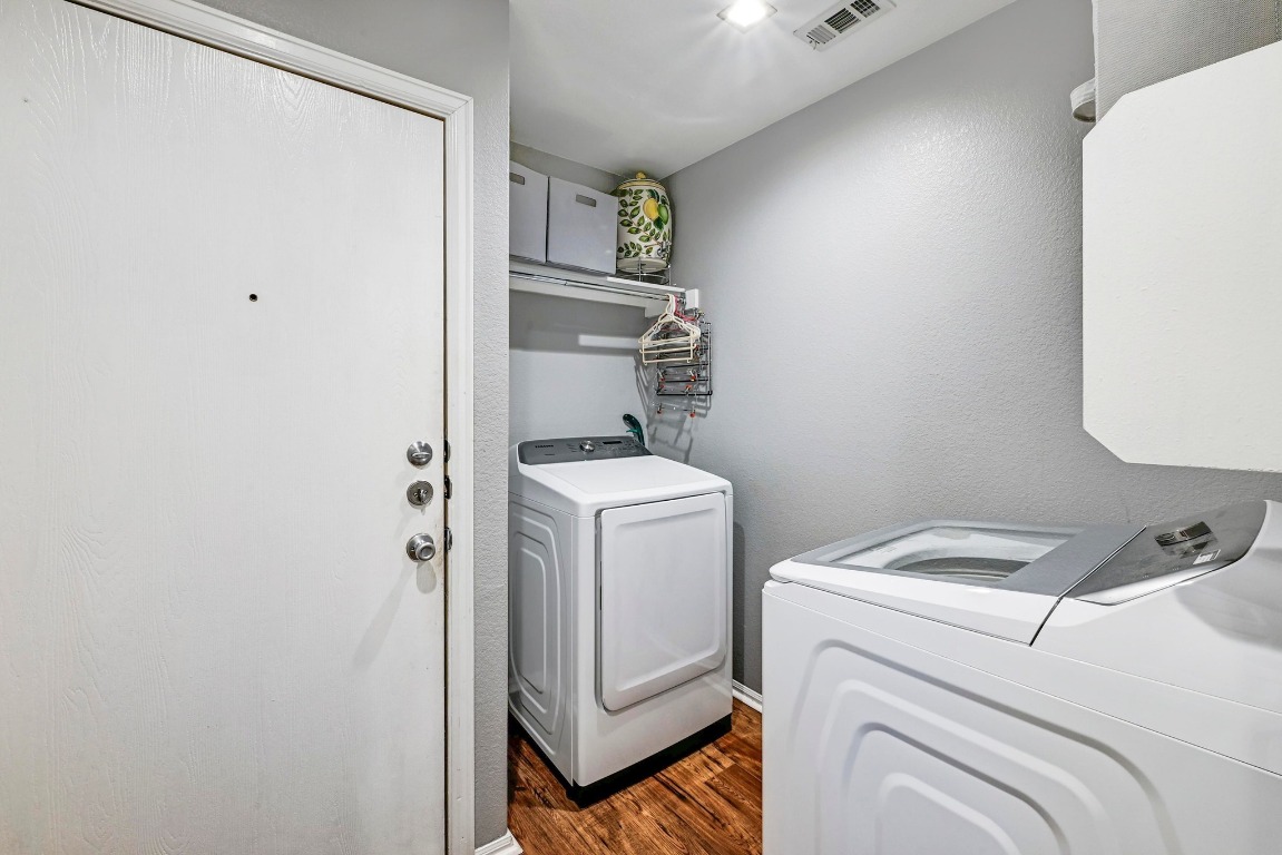 280 Spruce Drive Kyle, TX 78640 - Photo 22 of 30 Washroom featuring a textured wall, washing machine and clothes dryer, and dark wood-type flooring