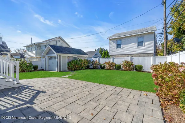 a large white kitchen with granite countertop lots of counter top space and stainless steel appliances
