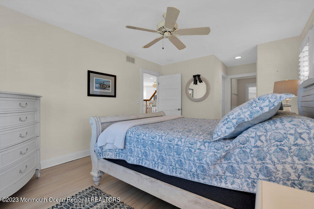 303 B Street Belmar, NJ 07719 - Photo 27 of 78 a bedroom with a large bed and a chandelier