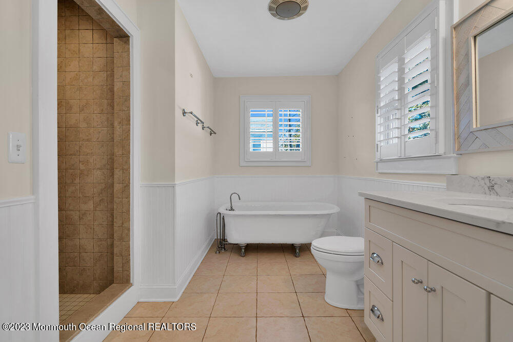 303 B Street Belmar, NJ 07719 - Photo 30 of 78 a bathroom with a granite countertop toilet a sink and a bathtub
