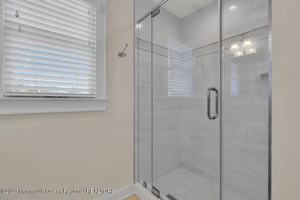 a bathroom with a glass door shower and a sink