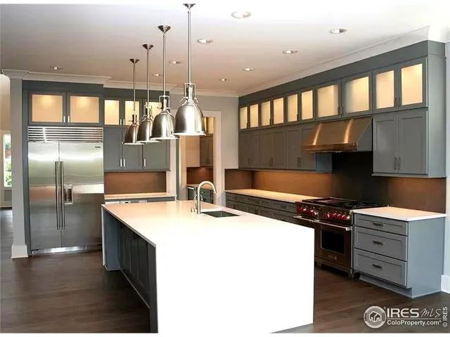 a kitchen with stainless steel appliances a sink a counter space and a view of living room