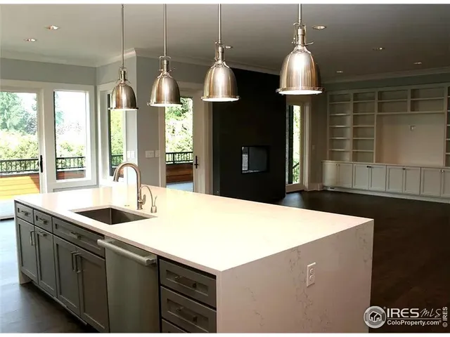 a kitchen with kitchen island a counter top space appliances and a ceiling fan