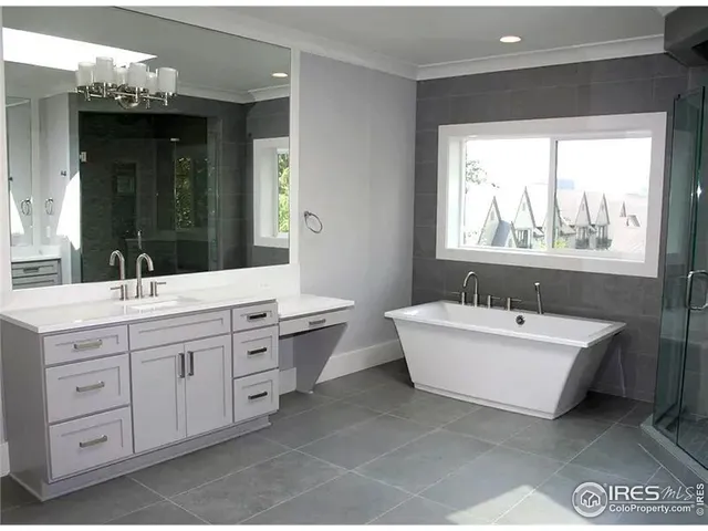 a bathroom with a double vanity sink a mirror and a bathtub