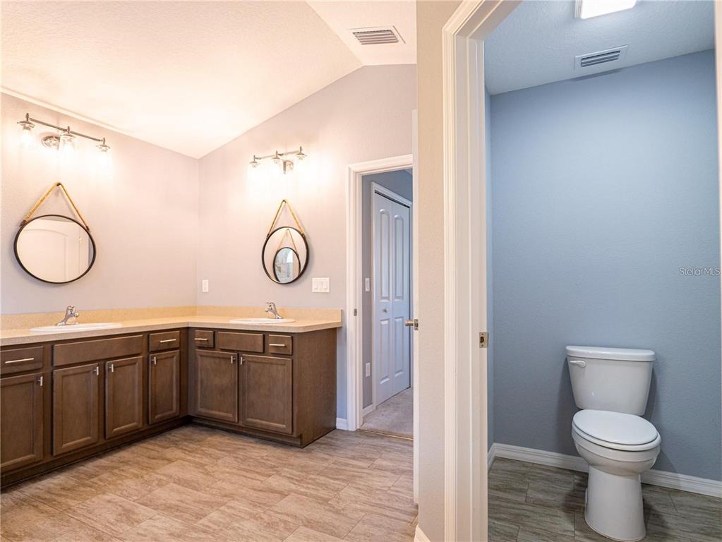 10688 Southwest 129th Terrace Road Dunnellon, FL 34432 - Photo 24 of 35 a bathroom with a toilet a sink and a mirror