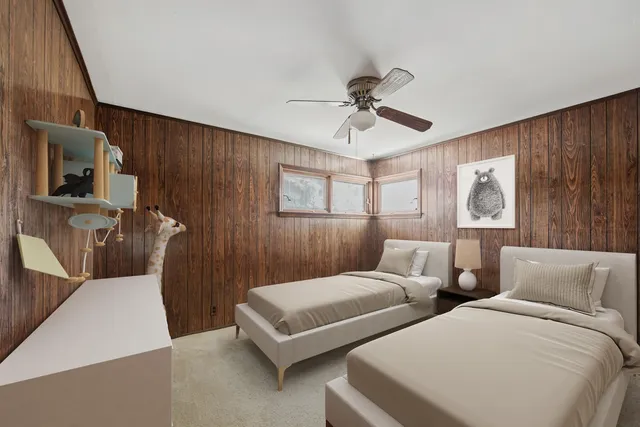 a bedroom with two beds and a mirror