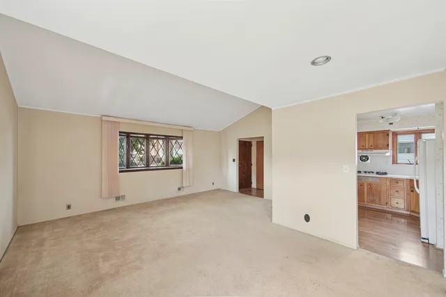 a view of an empty room with a cabinet and door
