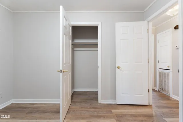 a view of empty room with wooden floor