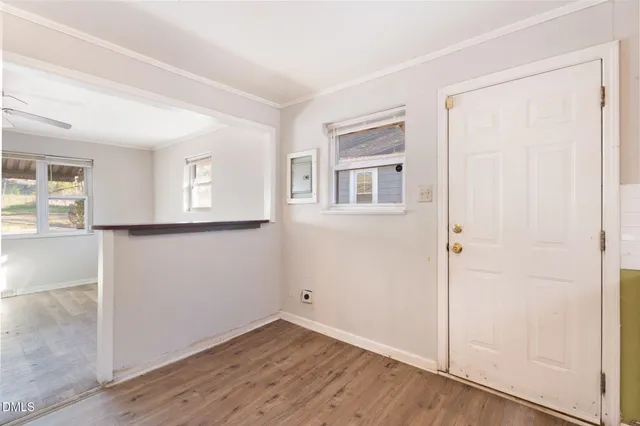 an empty room with wooden floor and windows