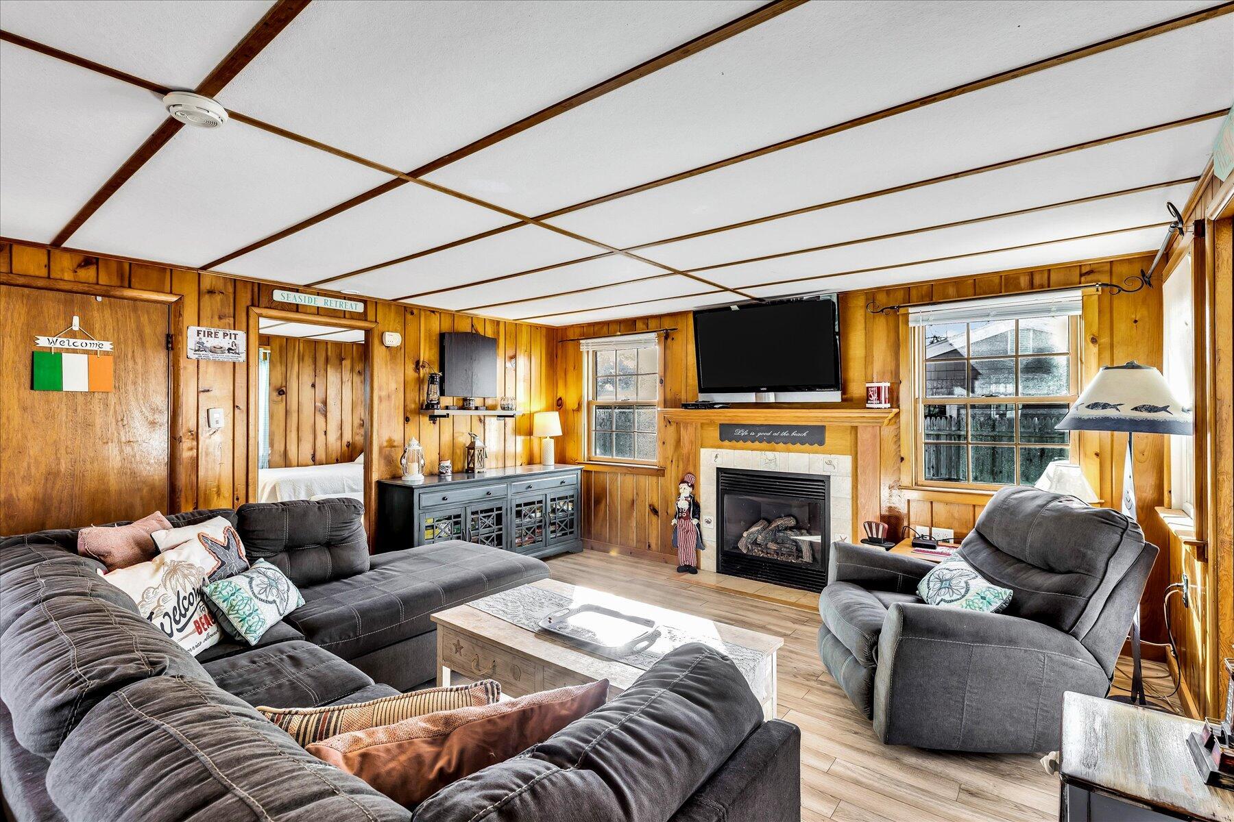 22 Edwards Road Dennis Port, MA 02639 - Photo 25 of 40 a living room with furniture a fireplace and a floor to ceiling window