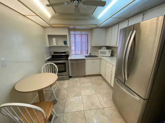 a kitchen with stainless steel appliances granite countertop a refrigerator sink and cabinets