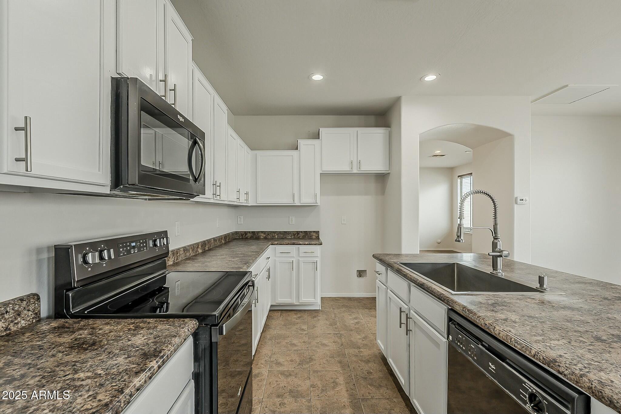 10122 West Payson Road Tolleson, AZ 85353 - Photo 23 of 56 a kitchen with sink stove and cabinets