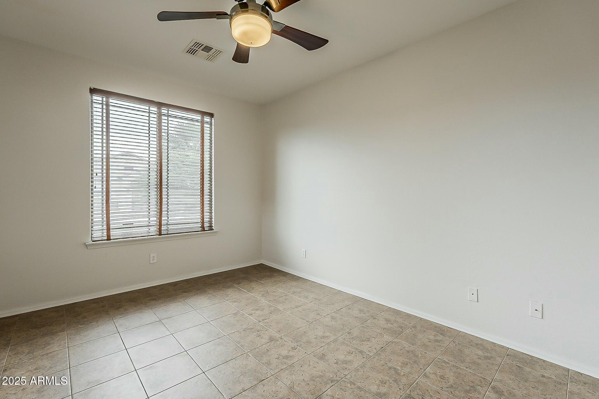 10122 West Payson Road Tolleson, AZ 85353 - Photo 41 of 56 an empty room with windows and fan
