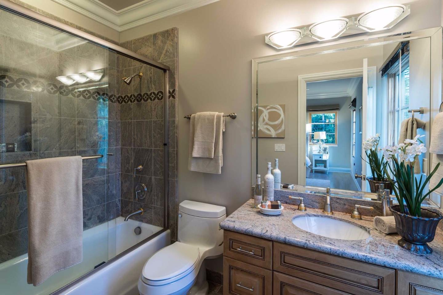 84 Nora Way Atherton, CA 94027 - Photo 24 of 37 a bathroom with a granite countertop sink toilet a mirror a bathtub and shower