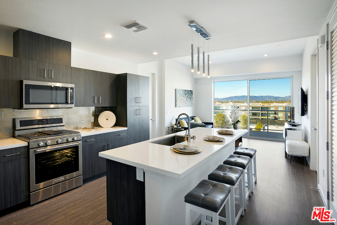 4140 Glencoe Avenue, Unit 604 Marina del Rey, CA 90292 - Photo 1 of 20 a kitchen with a sink a stove and chairs