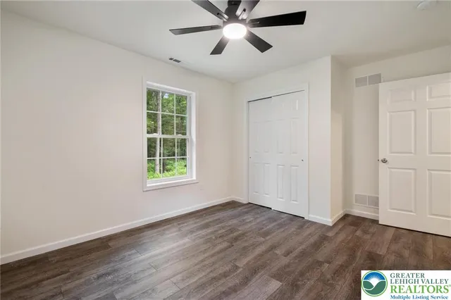 a view of a big room with wooden floor and windows