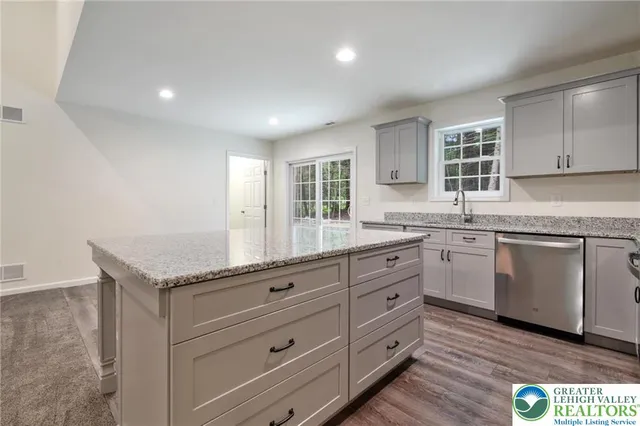 a kitchen with granite countertop white cabinets and white appliances