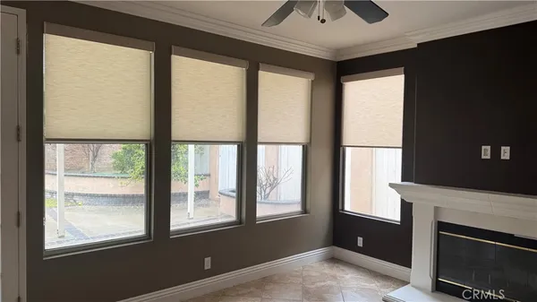 a view of an empty room with a window and kitchen view