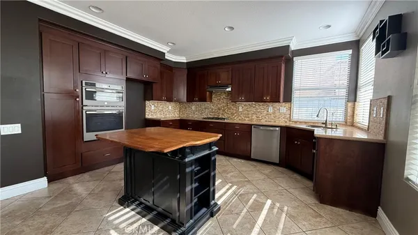 a kitchen with stainless steel appliances granite countertop a sink a stove and a refrigerator