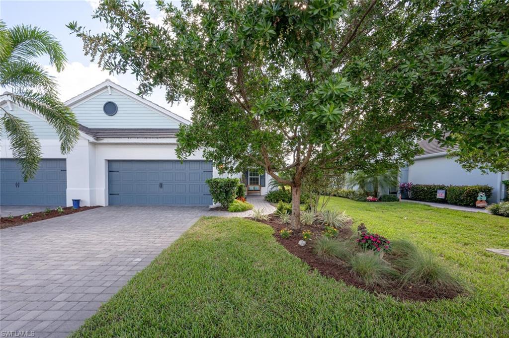 2247 Marquesa Circle Naples, FL 34112 - Photo 22 of 27 a front view of a house with a yard and trees