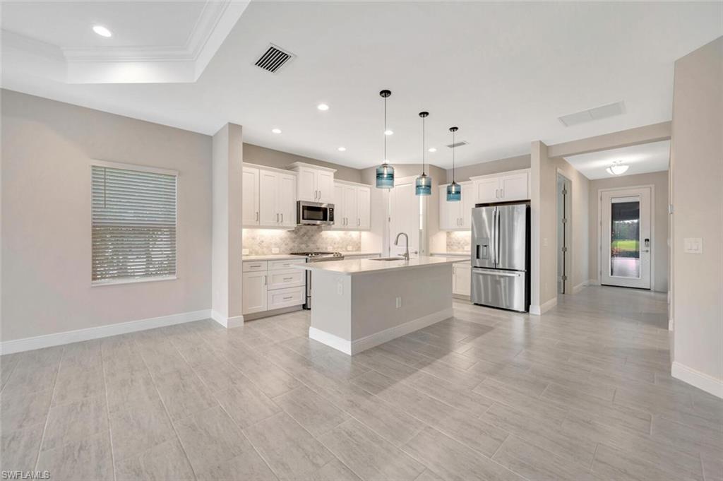 2247 Marquesa Circle Naples, FL 34112 - Photo 4 of 27 a large white kitchen with white cabinets and stainless steel appliances
