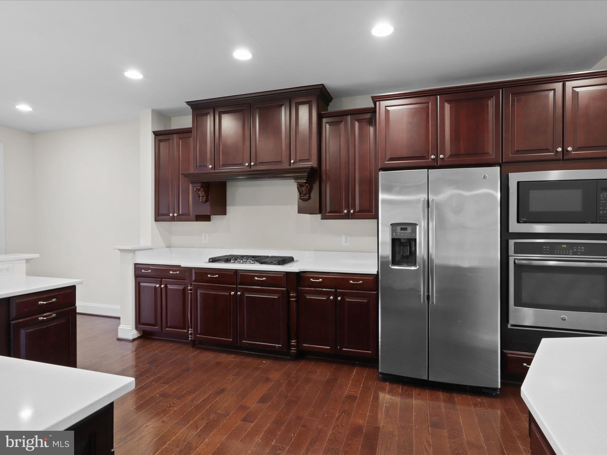 25138 Earlsdon Terrace Chantilly, VA 20152 - Photo 19 of 54 a kitchen with stainless steel appliances granite countertop wooden floors a stove a sink and a microwave