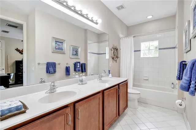 a bathroom with a granite countertop sink a toilet a mirror and shower