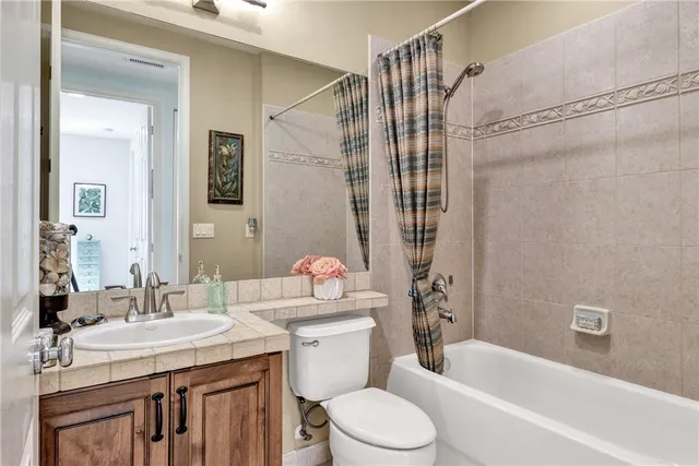 a bathroom with a granite countertop sink a toilet and shower