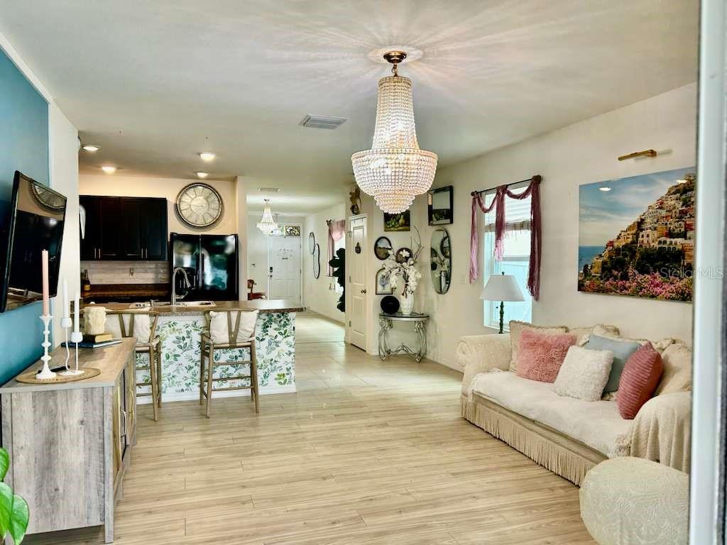 10214 Mangrove Well Road Sun City Center, FL 33573 - Photo 11 of 23 a living room with furniture kitchen view and a wooden floor