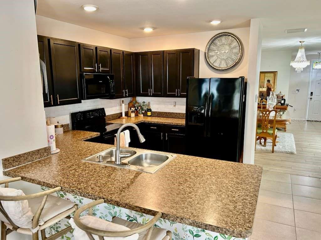 10214 Mangrove Well Road Sun City Center, FL 33573 - Photo 12 of 23 a kitchen with a refrigerator and a view of living room