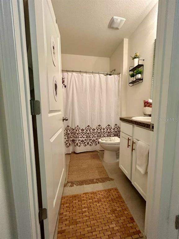 10214 Mangrove Well Road Sun City Center, FL 33573 - Photo 13 of 23 a bathroom with a sink a toilet and shower curtain