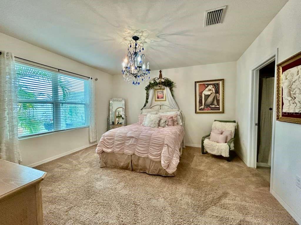10214 Mangrove Well Road Sun City Center, FL 33573 - Photo 18 of 23 a spacious bedroom with a bed and a couch