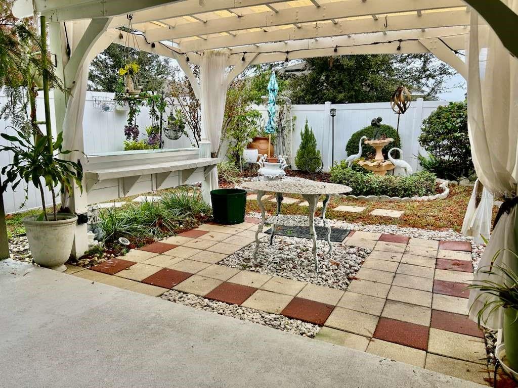 10214 Mangrove Well Road Sun City Center, FL 33573 - Photo 22 of 23 a view of a house with backyard sitting area and garden