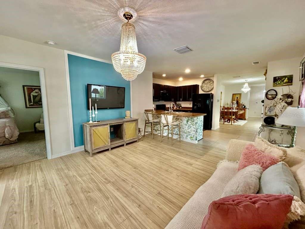 10214 Mangrove Well Road Sun City Center, FL 33573 - Photo 8 of 23 a view of a living room and kitchen with a flat screen tv