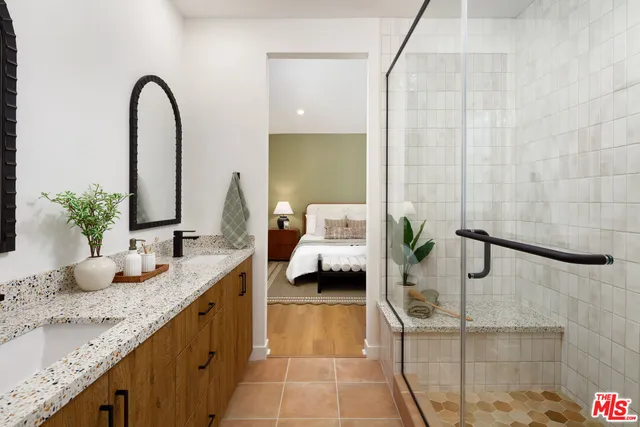 a en suite bathroom with a granite countertop sink and a mirror