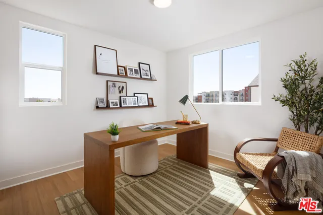 a living room with furniture a window and a potted plant