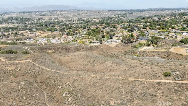 an aerial view of residential houses with outdoor space and trees
