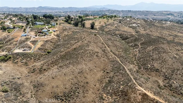 a view of a dry yard with mountains and green space