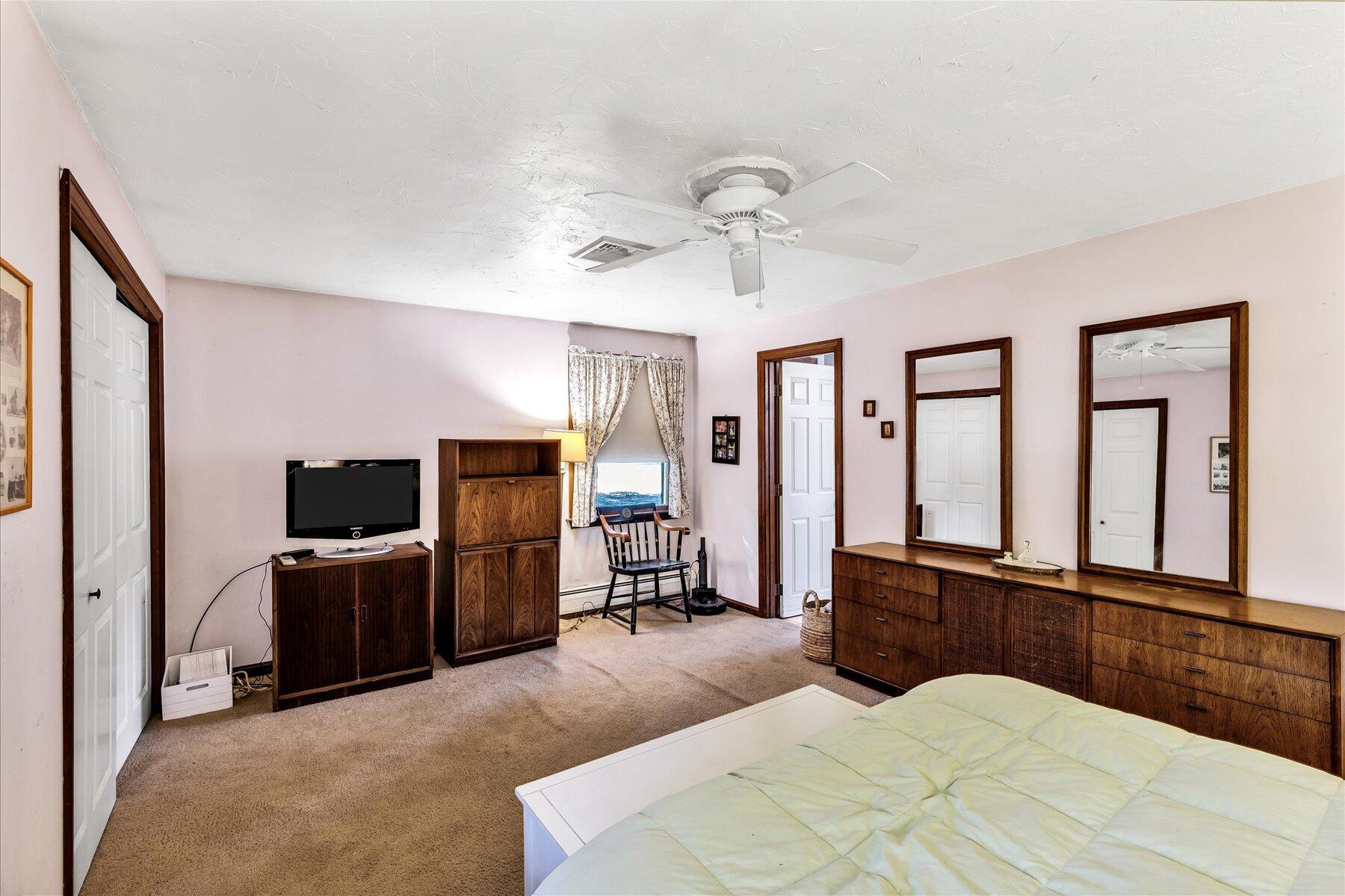 11 Barnacle Lane Mashpee, MA 02649 - Photo 30 of 38 a bedroom with a bed flat screen tv and windows