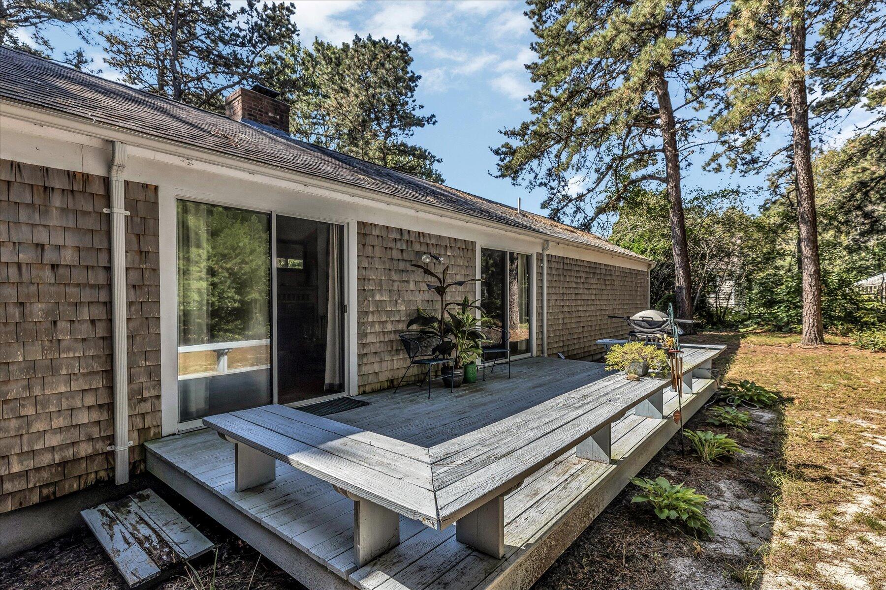 11 Barnacle Lane Mashpee, MA 02649 - Photo 33 of 38 a backyard of a house with barbeque oven table and chairs