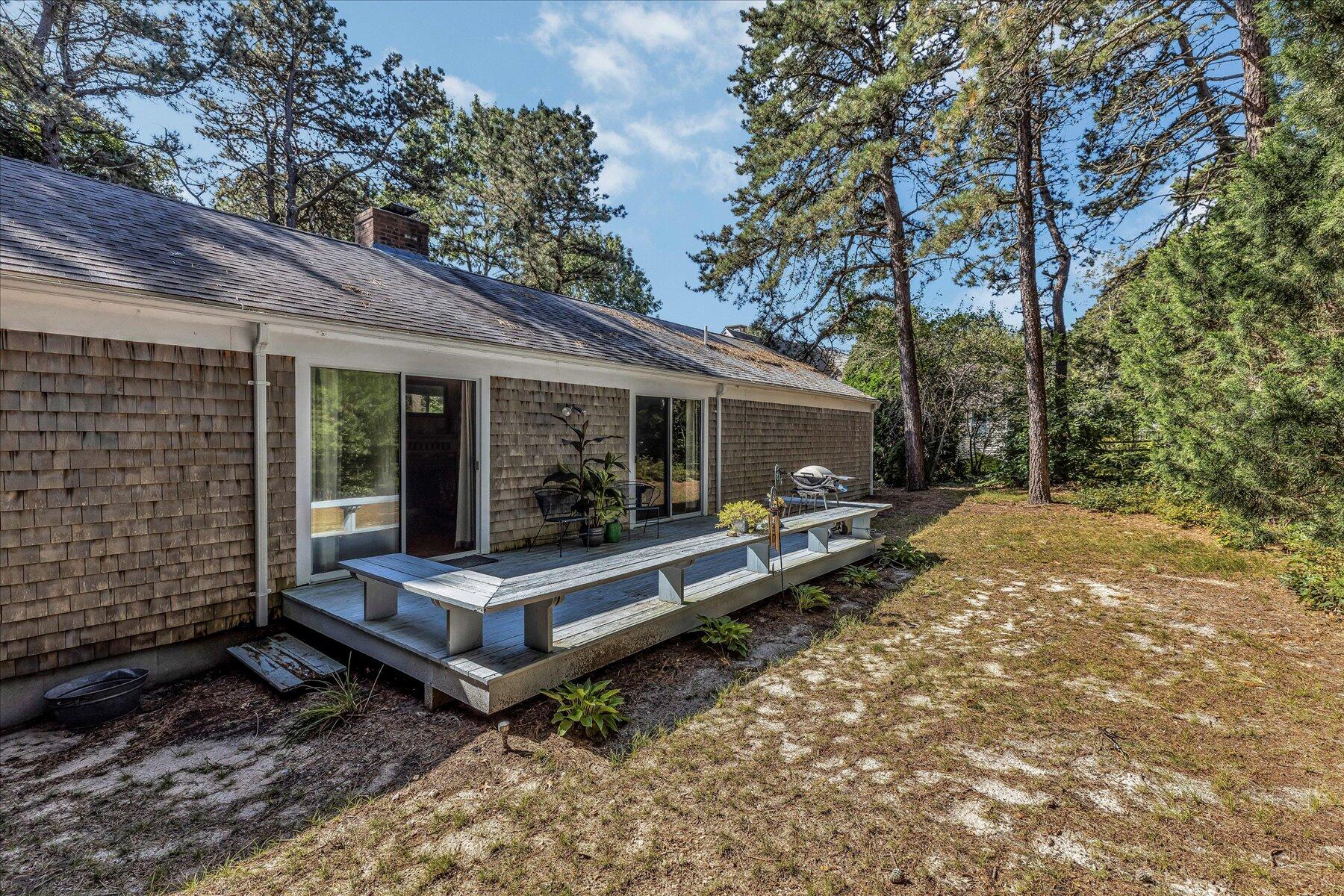 11 Barnacle Lane Mashpee, MA 02649 - Photo 35 of 38 a view of a wooden bench sitting in backyard of house