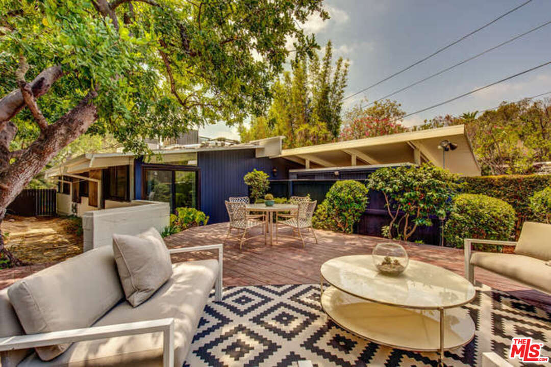 810 Bramble Way Los Angeles, CA 90049 - Photo 11 of 32 a view of a patio with table and chairs potted plants and a large tree