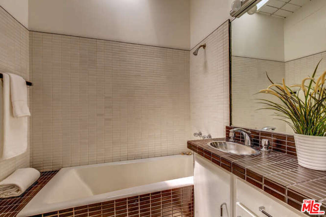 810 Bramble Way Los Angeles, CA 90049 - Photo 16 of 32 a bathroom with a shower curtain and a sink