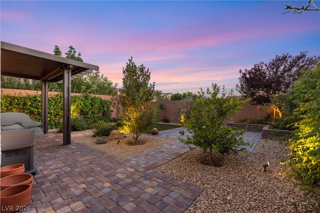 891 Earth Luster Road Las Vegas, NV 89178 - Photo 37 of 48 An inviting backyard oasis offers both paved and gravel paths, perfect for evening entertaining under the vibrant sky.