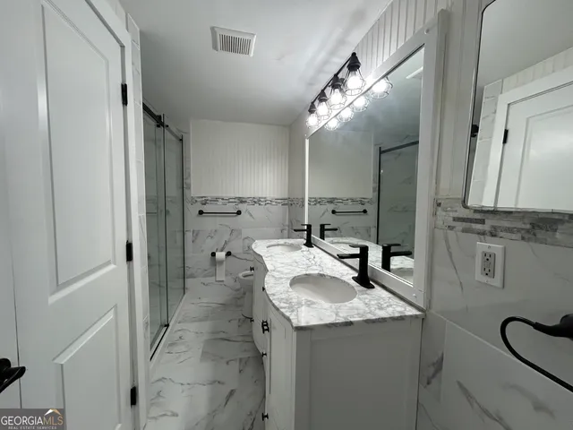 a bathroom with a granite countertop sink and a mirror