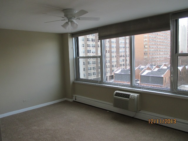336 West Wellington Avenue, Unit 604 Chicago, IL 60657 - Photo 3 of 9 an empty room with a window and a chandelier