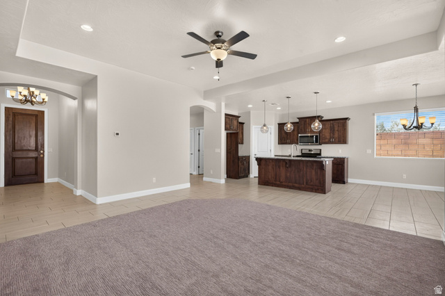 11 East 640 South Ivins, UT 84738 - Photo 8 of 44 Spacious room featuring tray ceilings, a ceiling fan with integrated lighting, recessed lighting, and mixed flooring with carpet and tile